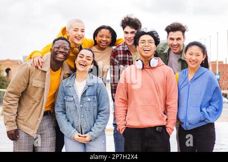 Porträt einer großen Gruppe von multirassischen jungen Freunden im Teenageralter, die lächeln und in die Kamera schauen. Von vorne sehen Sie viele glückliche Schüler, die lachen und gemeinsam Spaß im Freien haben. Freundschaftskonzept. Hochwertiges Foto Stockfoto