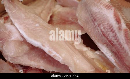 Frischer roher Lachs, Stör, dorado-Fisch und Wolfsbarsch liegen auf dem Tisch mit Eis auf dem Fischmarkt. Offene Regale in einem Fischladen. Nahaufnahme Stockfoto