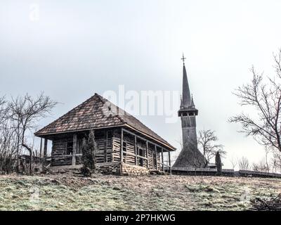 Altes Holzhaus und eine hölzerne orthodoxe Kirche in Maramures - im Baia Mare Village Museum Stockfoto