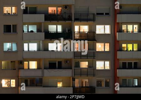 Beleuchtete Appartementfenster bei Nacht im Stadtgebäude Stockfoto