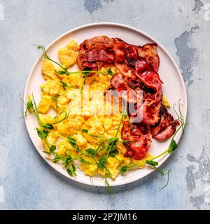 Traditionelles Frühstück, Rührei mit gebratenem Speck. Draufsicht. Stockfoto