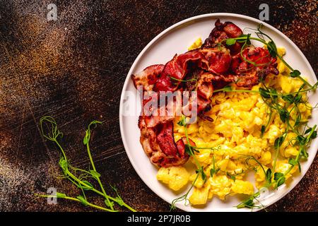 Traditionelles Frühstück, Rührei mit gebratenem Speck. Draufsicht. Stockfoto