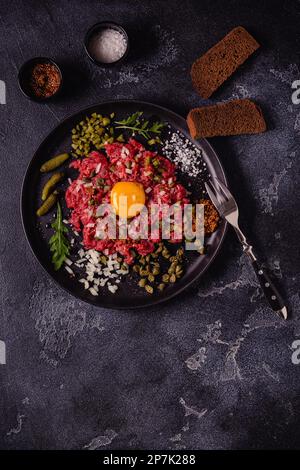 Frische Rindertartar mit leckerem Gemüse, Draufsicht. Stockfoto