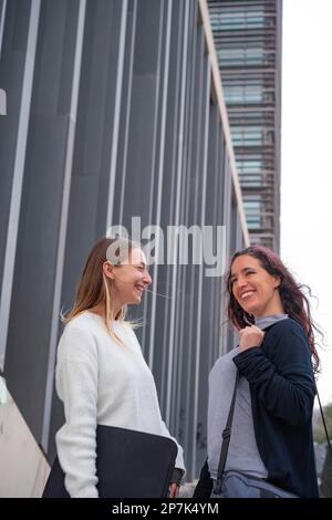 Zwei Studenten, die vor einem Studio-Center reden und lächeln. Fernstudium, Erwachsene Studenten Stockfoto