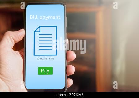 Nahaufnahme eines Handys mit App-Schnittstelle für die Online-Rechnungszahlung auf dem Bildschirm und grüner Schaltfläche „Bezahlen“. Platz für Text kopieren. Stockfoto