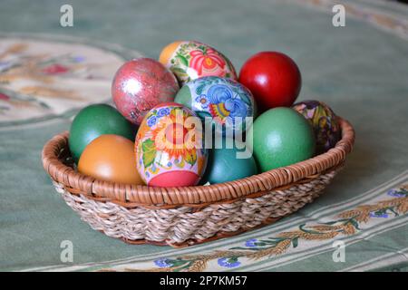 Nahaufnahme eines Webkorbs mit bunten gefärbten Eiern für die traditionelle Osterfeier in Bulgarien im april. Horizontales Bild mit selektivem FO Stockfoto