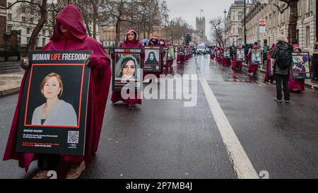 Auf Whitehall marschierten britisch-iranische Demonstranten, die wie Figuren aus dem Magazin des Magazins am Internationalen Frauentag 2023 gekleidet waren. Stockfoto