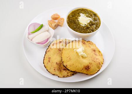 Sarson saag mit Maiskapitaten serviert mit weißem Makhan und Raggery auf Platte isoliert auf weißem Hintergrund Stockfoto