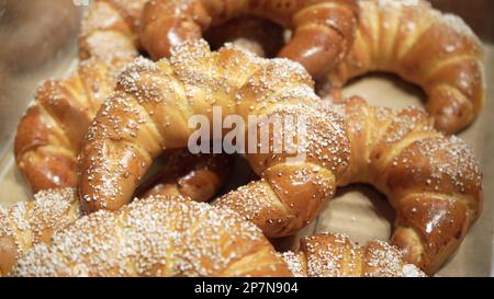 Reihen von warmen, frisch gebackenen Brötchen im Bäckereistand im örtlichen Lebensmittelgeschäft Stockfoto