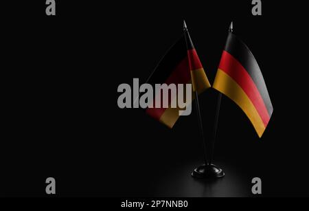Kleine Nationalflaggen der Bundesrepublik Deutschland auf schwarzem Hintergrund Stockfoto