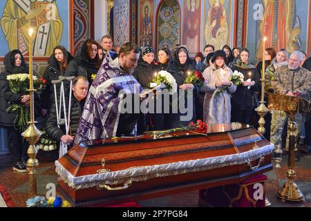 Ein Priester betet neben dem Sarg mit dem Leichnam des Soldaten Oleksiy Sokolovsky während einer Gedenkfeier in St. Michaels Kathedrale in Kiew. Oleksiy Sokolovsky war an den Feindseligkeiten beteiligt, die Russland 2014 im Donezk eingeleitet hatte, als er bei schweren Kämpfen in der Nähe von Donezk verwundet wurde, wofür er den Orden des Mutes III. Doch nach der massiven Invasion Russlands im Jahr 2022 verließ er Oleksiy erneut und starb am 7. Februar 2023 in der Nähe von Bakhmut, wo das Militär der Russischen Föderation derzeit offensiv operiert. (Foto: Oleksandr Gusev/SOPA Image Stockfoto