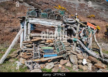 Angelhütte zwischen Staithes & Runswick Bay Yorkshire im verlassenen Hafen von Port Mulgrave, mit Treibholz, alten Flößen, sowie Hummer- oder Krabbentöpfen. Stockfoto