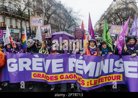 Jan Schmidt-Whitley/Le Pictorium - Demonstration für Frauenrechte in Paris - 8/3/2023 - Frankreich / Paris / Paris - weibliche Demonstranten hinter einem feministischen Banner in der Demonstration. Mehrere Zehntausende Menschen haben sich am 8. März in Paris im Regen versammelt, um die Rechte der Frauen zu verteidigen. Diese Mobilisierung ist Teil der Protestbewegung gegen die Rentenreform unter der Leitung der Regierung Elisabeth Borne. Stockfoto