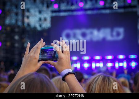 Junge Leute machen Fotos oder Videos von einem Konzert auf Smartphones Stockfoto
