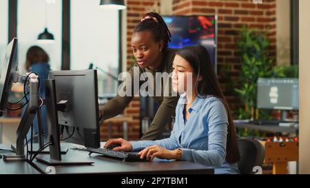 Team der Produktionsabteilung, das mithilfe kreativer Fähigkeiten und künstlicher Intelligenz Ideen zur Erstellung künstlerischer Online-Inhalte sammelt. Frauen, die in der App- oder Spieleentwicklung arbeiten, professionelle Arbeit. Stockfoto