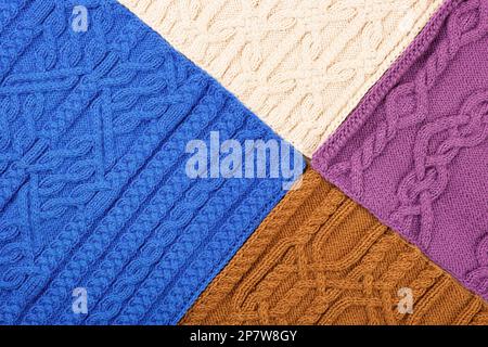 Gestrickter Hintergrund in Blau, Lila, Braun und Beige. Großer Strickstoff mit Muster. Nahaufnahme einer Strickdecke. Banner Stockfoto