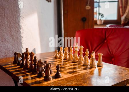 Nahaufnahme von braunen und weißen Schachfiguren, die auf dem Schachbrett im Hotel angeordnet sind Stockfoto