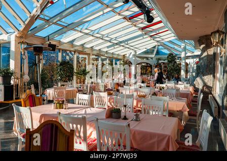 Inneneinrichtung des Luxushotels mit Tisch und Stühlen, die an sonnigen Tagen arrangiert sind Stockfoto