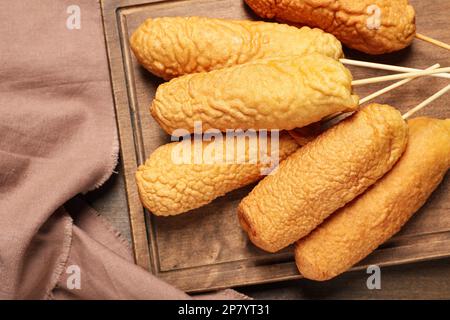 Köstliche, frittierte Corn Dogs auf einem Holztisch, Blick von oben Stockfoto