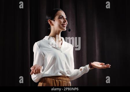 Motivationslautsprecher mit Headset, das auf der Bühne läuft Stockfoto