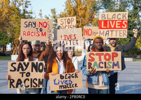 Demonstranten, die im Freien verschiedene Anti-Rassismus-Slogans demonstrieren. Personen, die Schilder mit Phrasen halten Stockfoto