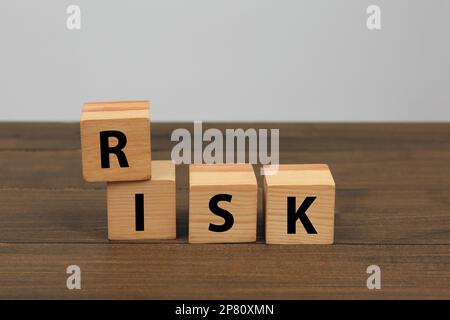 Würfel mit Wortrisiko auf Holztisch Stockfoto