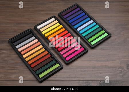 Bunte Pastelltöne in Tabletts auf Holztisch. Zeichenmaterialien Stockfoto