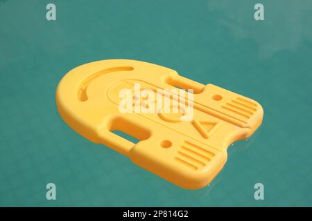 Schwimmendes Kickboard aus Plastik, schwimmend im erfrischenden blauen Swimmingpool Stockfoto