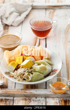 Kupat Tahu Singaparna, typisches Frühstück aus West Java, Indonesien. Komprimierter Reiskuchen mit gelbem Tofu, Sprout und würziger Erdnusssoße Stockfoto