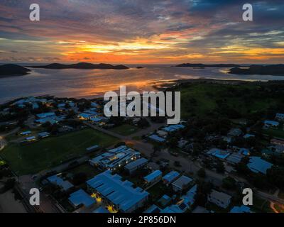 Orangefarbener Sonnenuntergang über dem Strand und der Stadt Torres Strait, Stockfoto