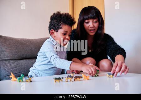 Mutter und Sohn spielen zu Hause auf dem Sofa Stockfoto