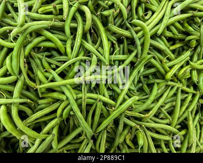 Französische grüne Bohnen oder Haricots Verts oder Common Green Beans auf einem Frischmarkt zum Verkauf. Draufsicht Stockfoto