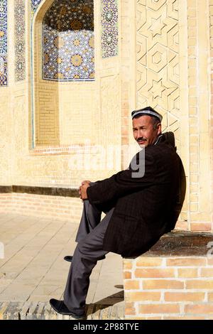 Porträt eines usbekischen Mannes, aufgenommen von der Kalan-Moschee und dem Innenhof in der Altstadt von Bukhara, Usbekistan. Stockfoto