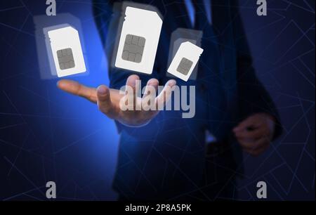 Ein Mann, der SIM-Karten verschiedener Größen auf farbigem Hintergrund vorführt, Nahaufnahme Stockfoto