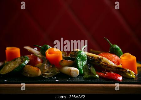 Im Ofen geröstetes Gemüsegericht wie Möhren, grüner Paprika, Tomaten und Porree. Stockfoto
