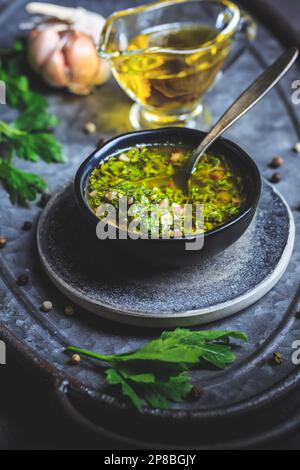 Chimichurri verde: Traditionelles argentinisches Gewürz aus fein gehackter Petersilie, gehacktem Knoblauch, Olivenöl, Oregano und Weinessig Stockfoto