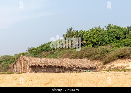 Candolim, Goa, Indien - Januar 2023: Eine rustikale Strohhütte an einem ruhigen tropischen Strand in Sinquerim. Stockfoto
