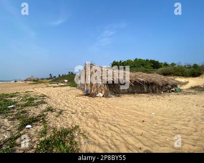 Candolim, Goa, Indien - Januar 2023: Eine rustikale Strohhütte an einem ruhigen tropischen Strand in Sinquerim. Stockfoto