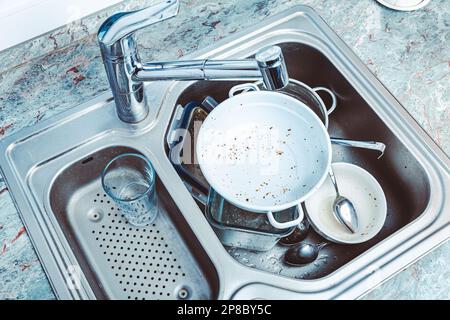 Geschirrspülmaschine - ein Haufen schmutzigem Geschirr im Spülbecken Stockfoto