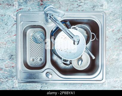Geschirrspülmaschine - ein Haufen schmutzigem Geschirr im Spülbecken Stockfoto