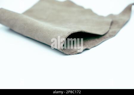 Graues Leder ist auf weißem Hintergrund gefaltet Stockfoto
