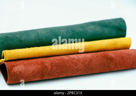 Rollen aus natürlichem, farbenfrohem Leder. Materialien für Lederfahrzeuge. Rotes, grünes und gelbes Wildleder Stockfoto