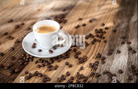 Kaffeetasse mit gerösteten Bohnen auf Holzhintergrund Stockfoto