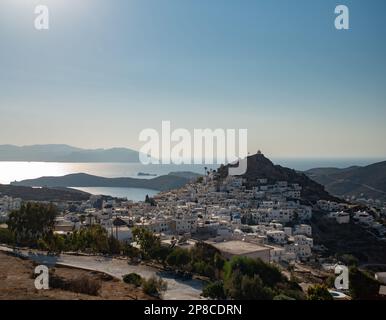 Ein wunderschöner Blick auf die untergehende Sonne über der Stadt voller weißer Häuser Griechenlands Stockfoto