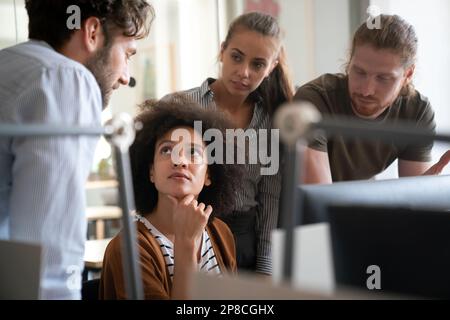 Lächelnd treffen sich verschiedene Kollegen in einem Brainstorming in der Vorstandsetage, um gemeinsam Finanzstatistiken zu diskutieren Stockfoto