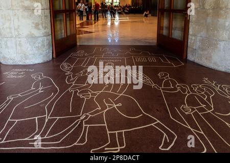 Barcelona, Spanien - 5. Oktober 2018: Zeichnung auf braunem Marmorboden vor dem Tor in die Kirche Sagrada Familia.