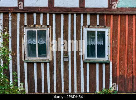 Holzwand des alten Hauses mit Fenster und Spitzenvorhängen Stockfoto