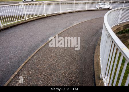 Spiralförmige Fahrradrampe über einer Autobahn Stockfoto