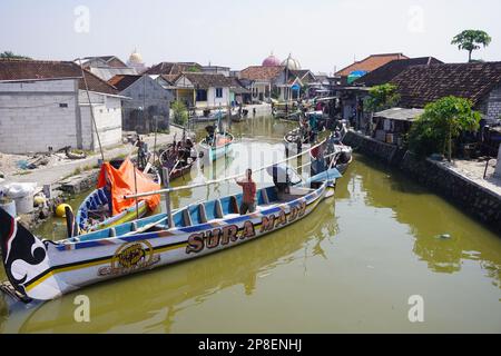 Fischer auf einem traditionellen Holzboot, bereit, die Segel zu setzen, um an einem sonnigen Tag Fische zu fangen Stockfoto