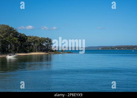 Blick von der Anlegestelle auf Coochiemudlo Island über das ruhige blaue Wasser der Moreton Bay nach Macleay Island und Stradbroke Island in der Ferne. Stockfoto